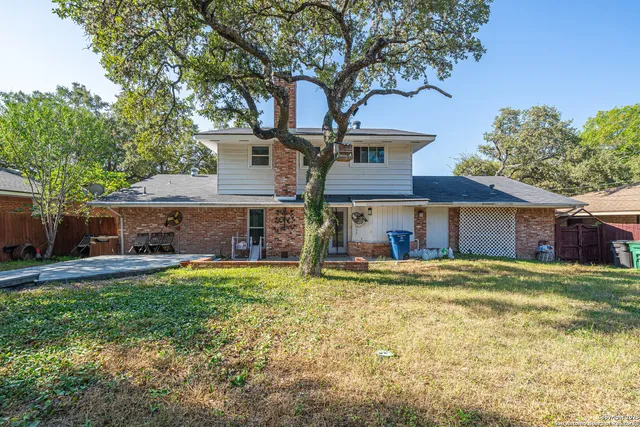 a view of a house with a yard and tree