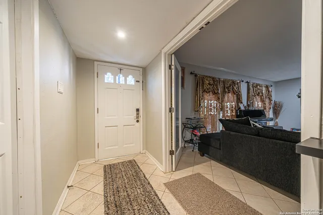 a view of a hallway and a livingroom with furniture