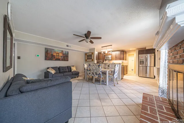 a living room with furniture and a dining table with kitchen view