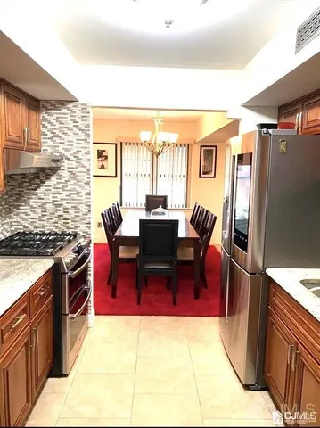 a kitchen with stainless steel appliances granite countertop a refrigerator and a stove