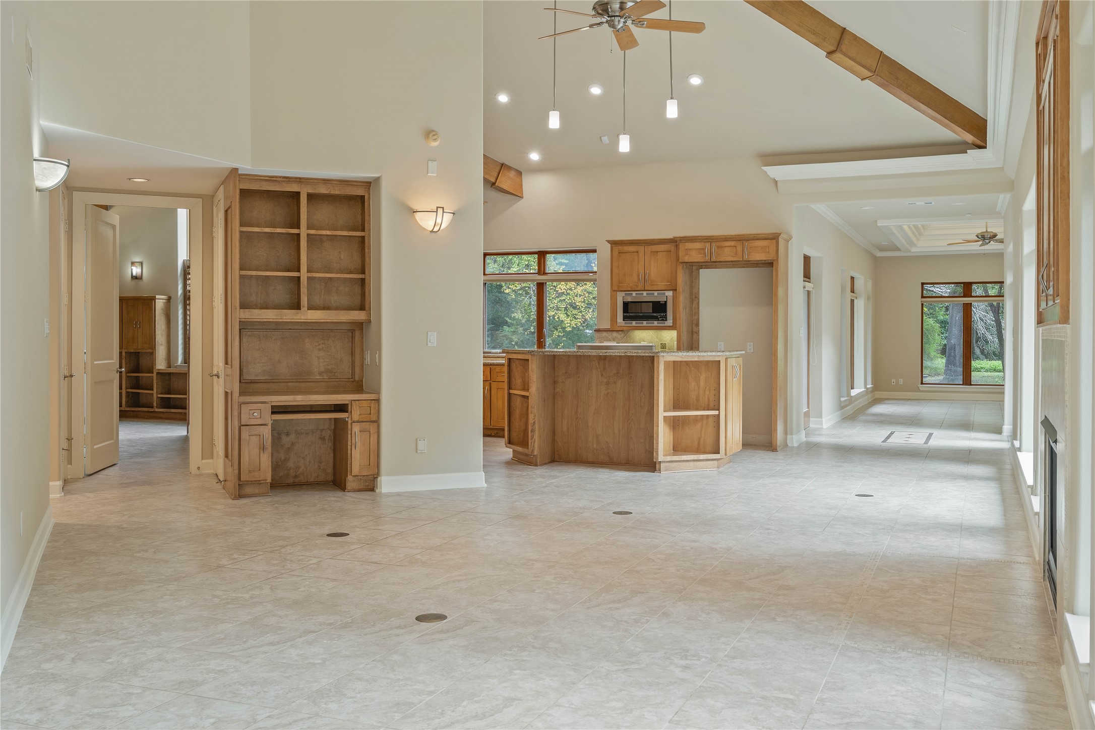 16621 Hereford Road Tomball, TX 77377 - Photo 13 of 46 This open-concept kitchen and family room boasts high ceilings, sleek tile floors, and abundant natural light, creating an inviting space perfect for both relaxation and entertaining.