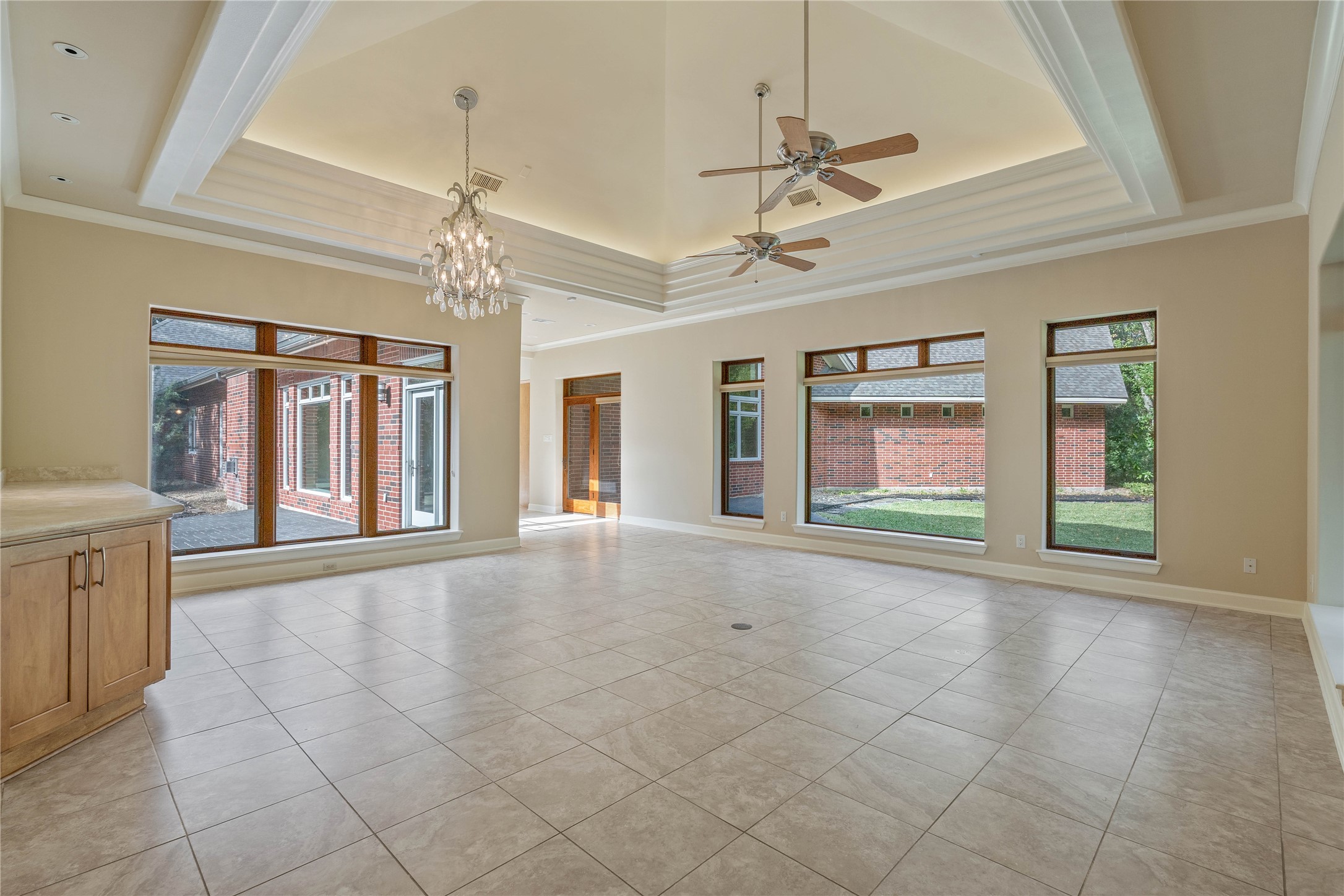 16621 Hereford Road Tomball, TX 77377 - Photo 16 of 46 Sunlit family room with expansive windows and elegant high ceilings, seamlessly guiding your view toward the inviting front of the home.