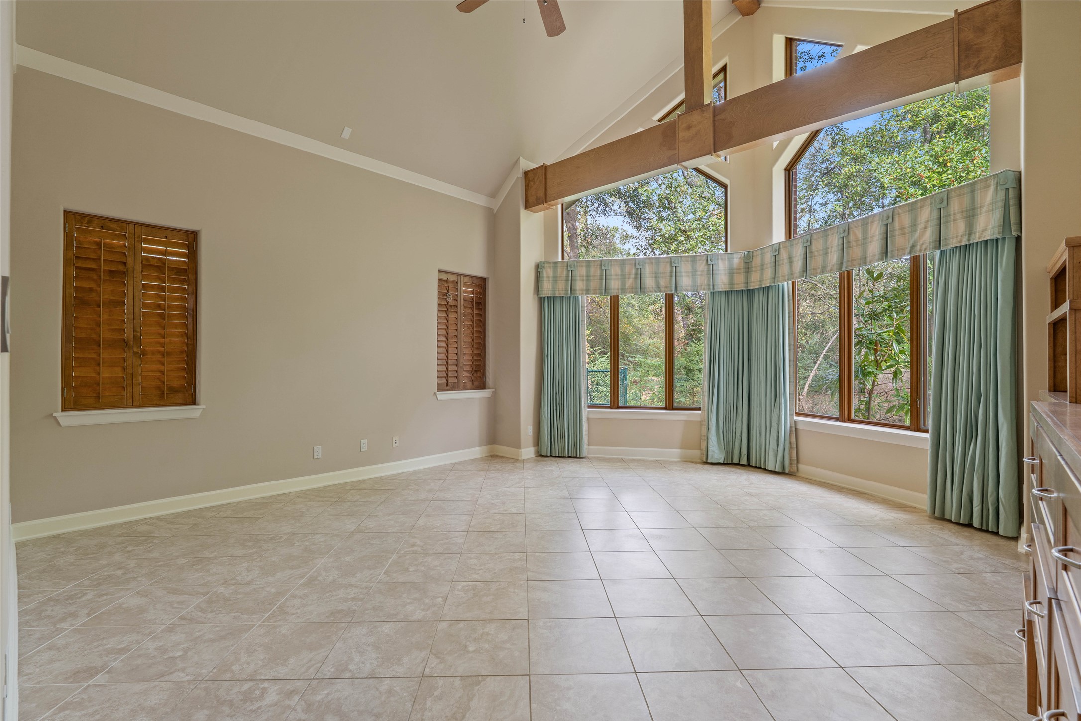 16621 Hereford Road Tomball, TX 77377 - Photo 18 of 46 Serene primary bedroom with soaring ceilings, abundant natural light from expansive windows, and elegant tile flooring, all creating a perfect retreat.