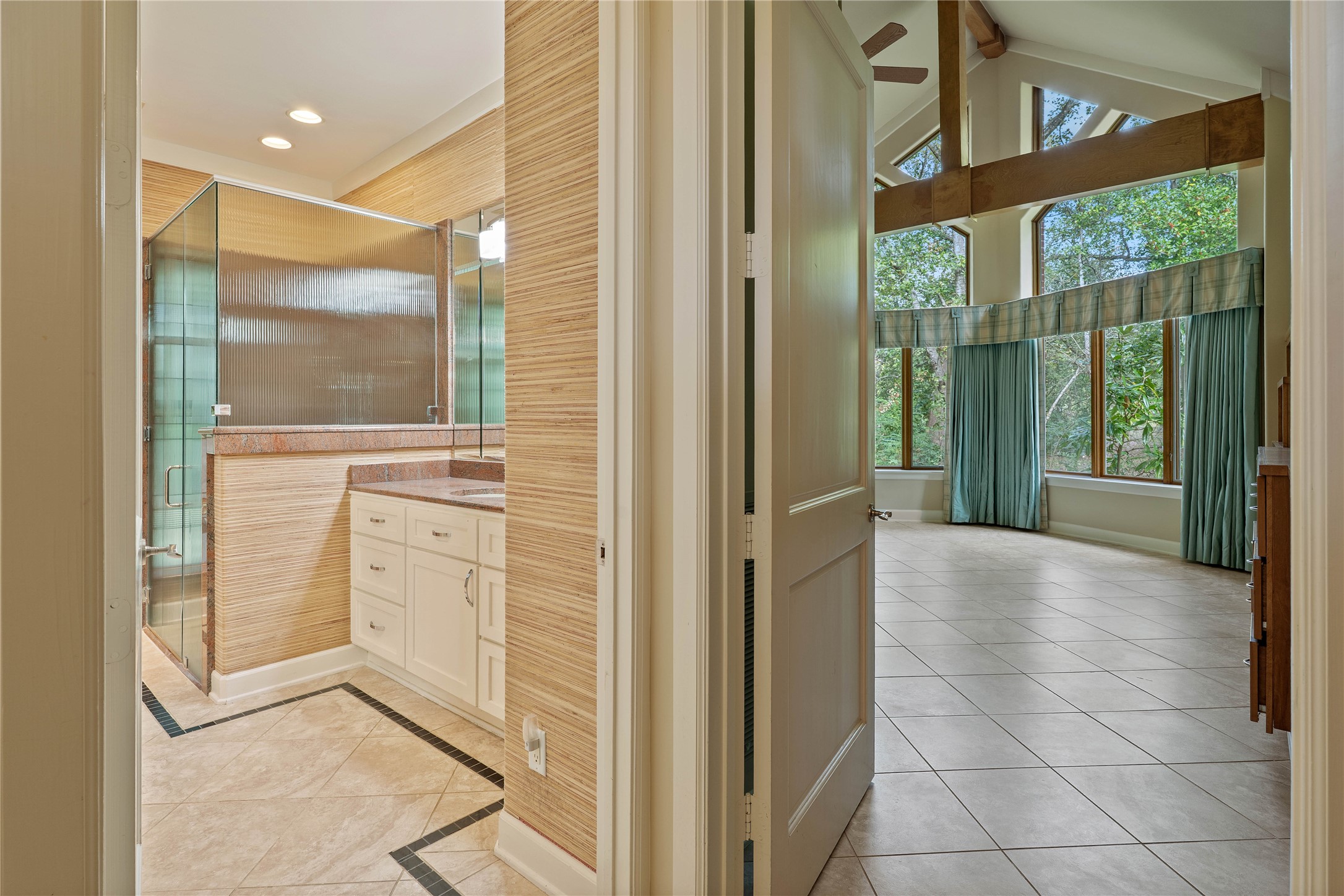 16621 Hereford Road Tomball, TX 77377 - Photo 21 of 46 Seamless blend of luxury and nature in this primary suite, featuring a spacious bedroom with expansive windows and a beautifully appointed bathroom for a serene retreat.