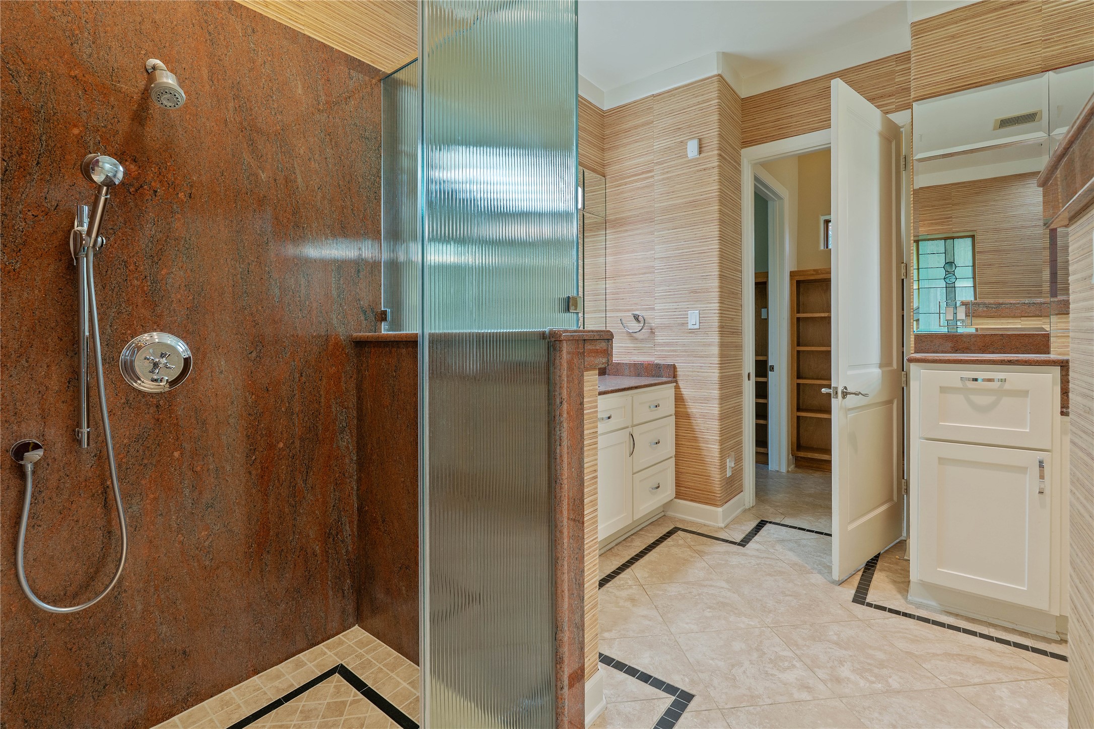 16621 Hereford Road Tomball, TX 77377 - Photo 22 of 46 A luxury spacious primary shower, featuring elegant stone accents and modern fixtures, seamlessly connected to a beautifully designed bathroom with ample cabinetry and stylish tile flooring.