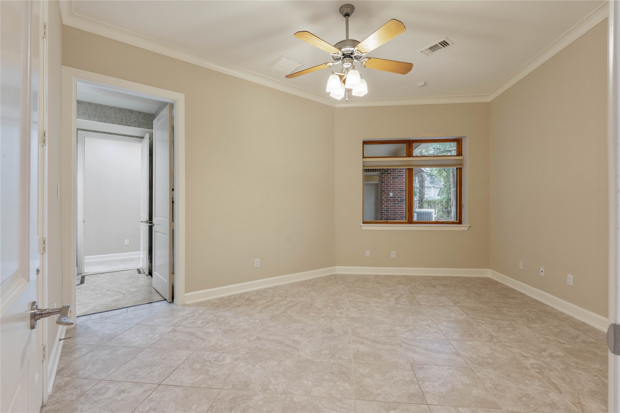 16621 Hereford Road Tomball, TX 77377 - Photo 26 of 46 This inviting bedroom features a warm neutral palette, elegant tile flooring, and a stylish ceiling fan, creating a serene and comfortable retreat.