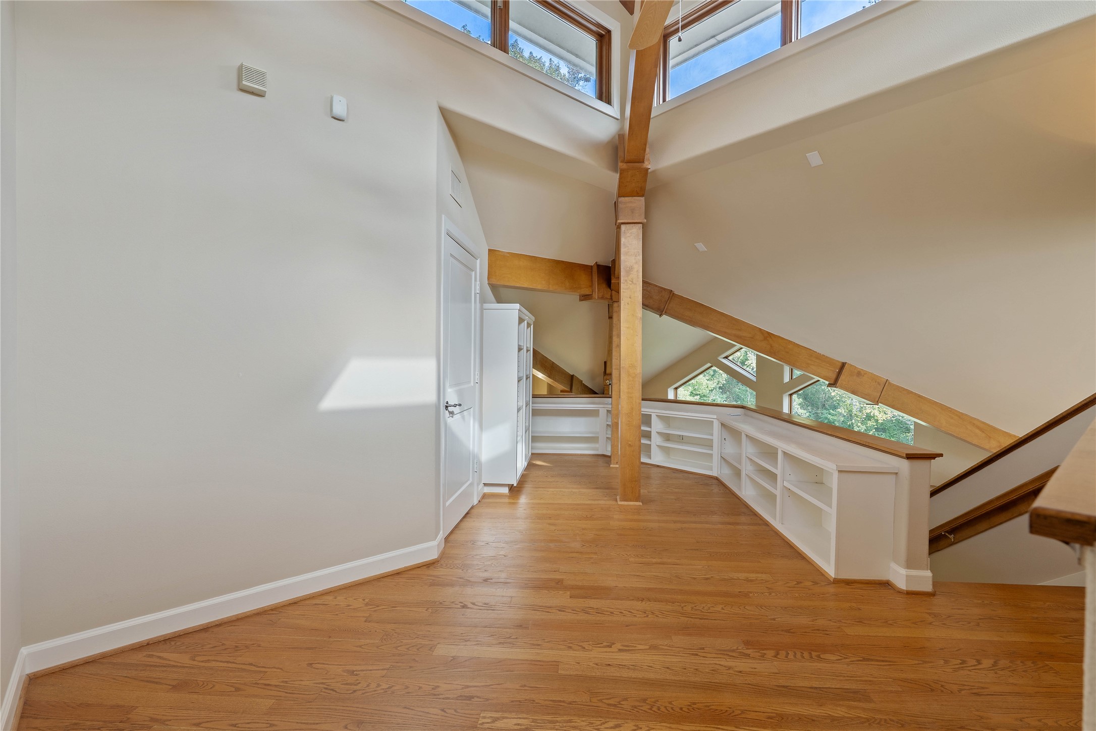 16621 Hereford Road Tomball, TX 77377 - Photo 30 of 46 Stunning loft area adorned with elegant wood beams and built-in bookshelves, perfect for a cozy reading nook.