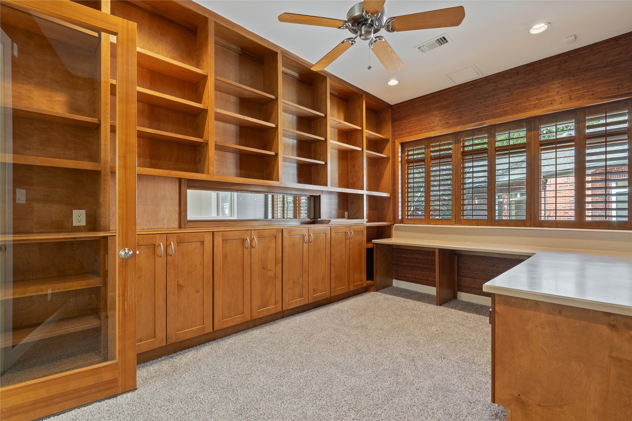 16621 Hereford Road Tomball, TX 77377 - Photo 35 of 46 A bright, inviting office space with rich wooden built-ins, ample shelving, and large windows.