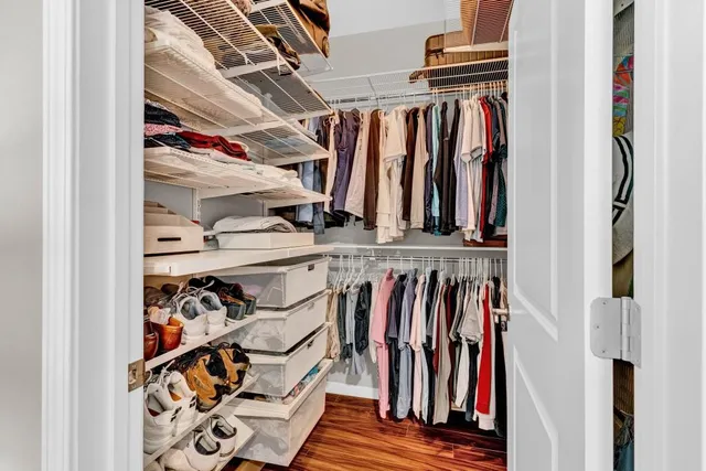 a view of walk in closet with clothes and shoes