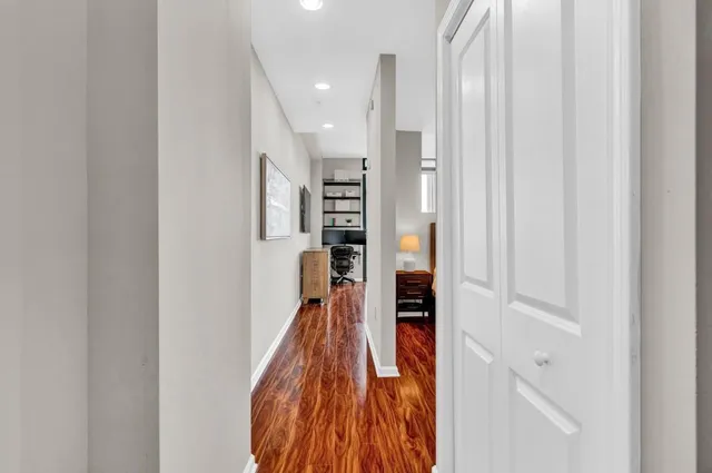a view of a hallway with wooden floor and staircase