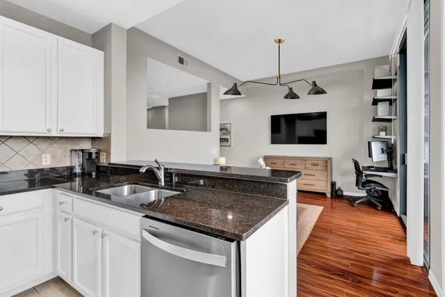 a kitchen with granite countertop a sink and a stove top oven