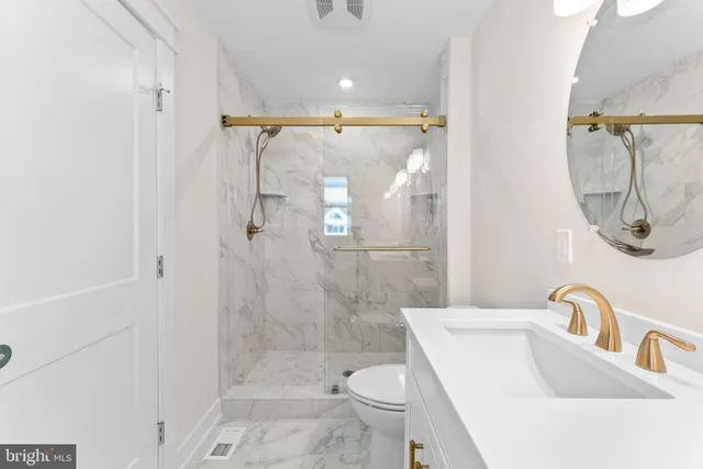 a bathroom with a sink a toilet and shower