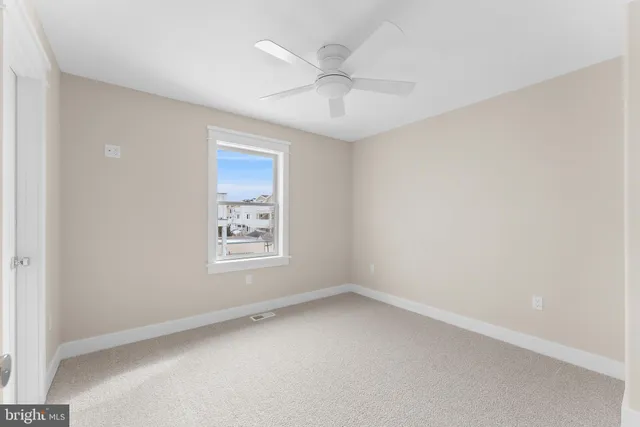 an empty room with a window and a ceiling fan