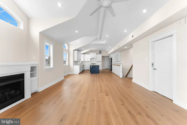 a view of empty room with wooden floor and fireplace