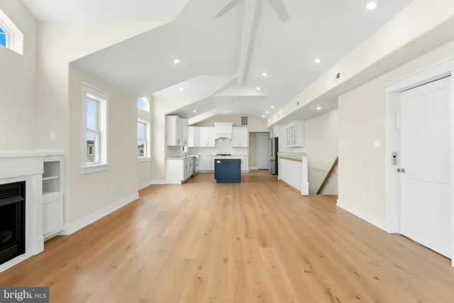 a big room with wooden floor and fireplace