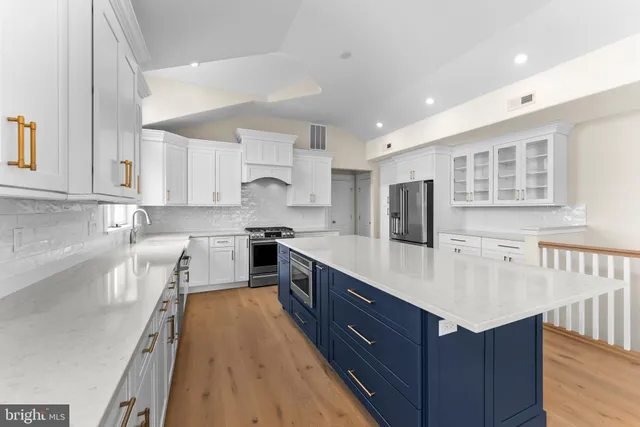 a large kitchen with stainless steel appliances sink a microwave and cabinets