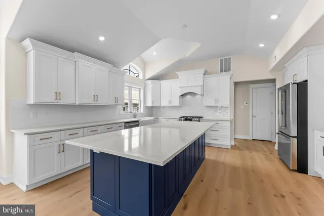 a kitchen with kitchen island granite countertop a sink stove and refrigerator