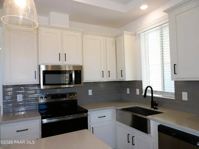 a kitchen with a sink and white cabinets