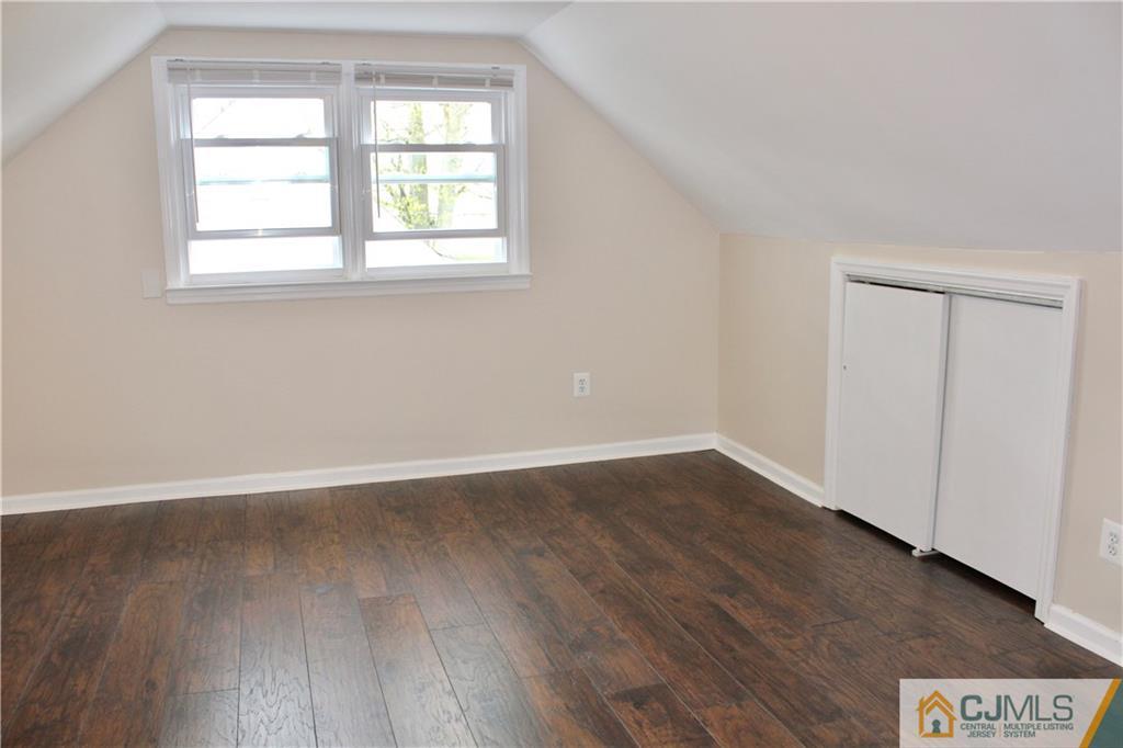 15 Roberts Road New Brunswick, NJ 08901 - Photo 22 of 25 an empty room with wooden floor and windows