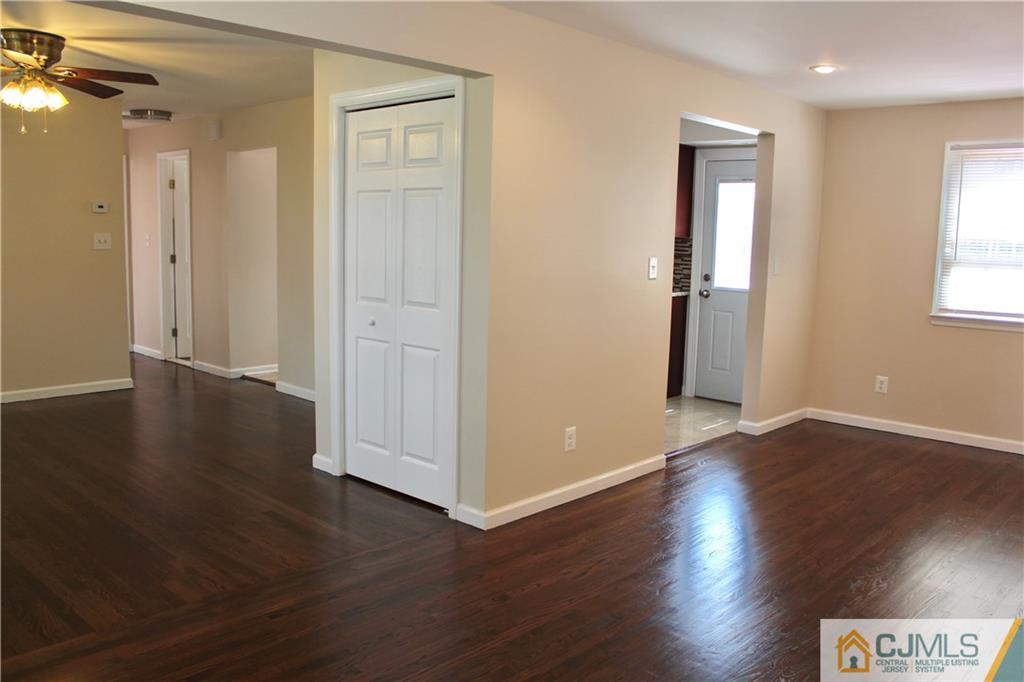 15 Roberts Road New Brunswick, NJ 08901 - Photo 7 of 25 an empty room with wooden floor and windows