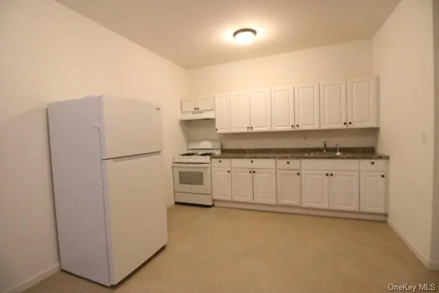 a kitchen with white cabinets and white appliances