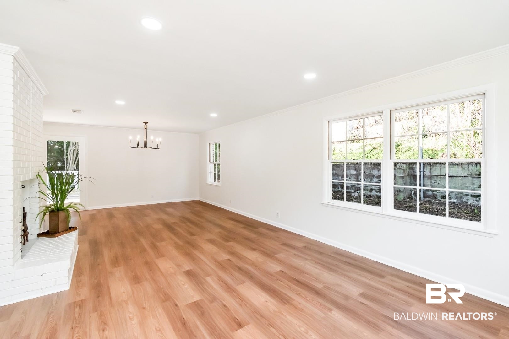 115 Pineridge Road Daphne, AL 36526 - Photo 7 of 34 Spare room featuring baseboards, light wood-style floors, a notable chandelier, and ornamental molding