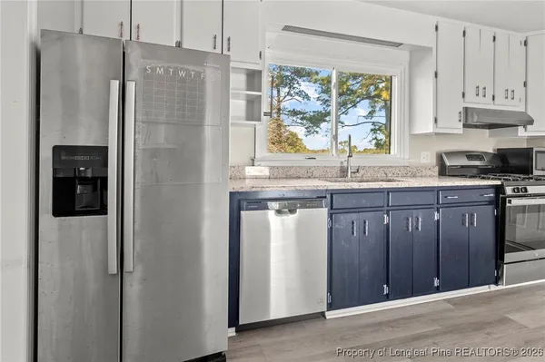 a kitchen with stainless steel appliances granite countertop a refrigerator and a sink