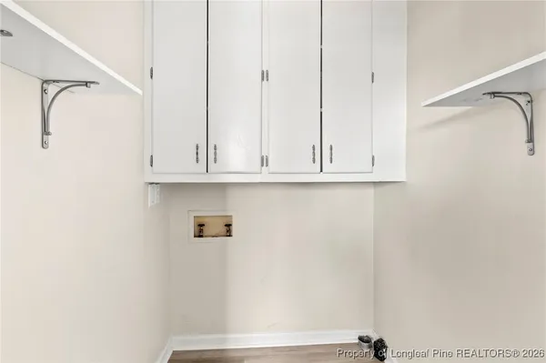 an empty room with wooden floor ceiling fan and windows