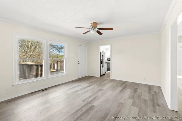an empty room with wooden floor and ceiling fan