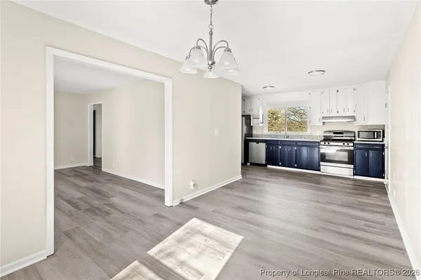 a view of a kitchen with wooden floor and a sink