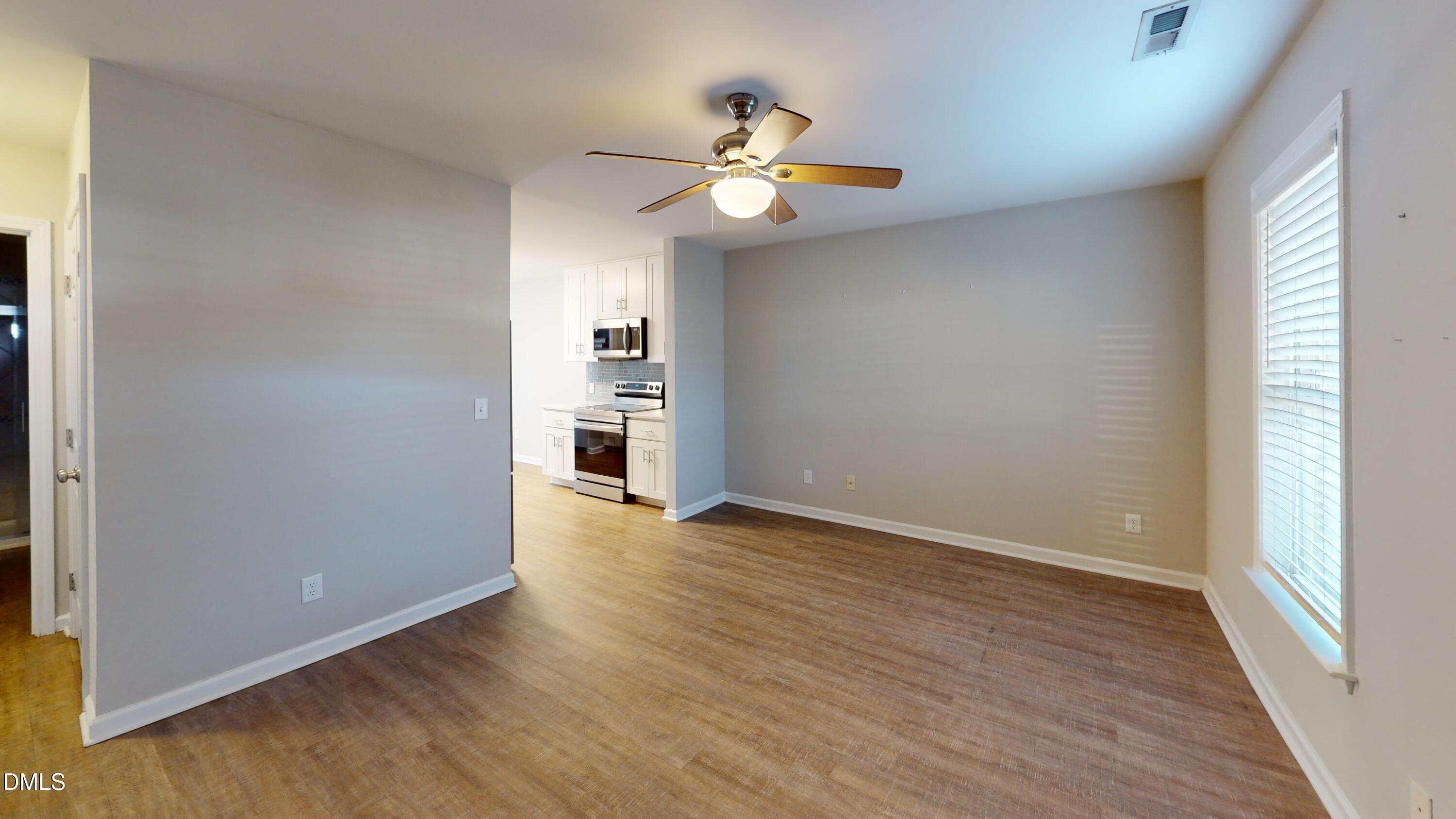 1312 South State Street, Unit A Raleigh, NC 27610 - Photo 4 of 12 wooden floor in an empty room with a window