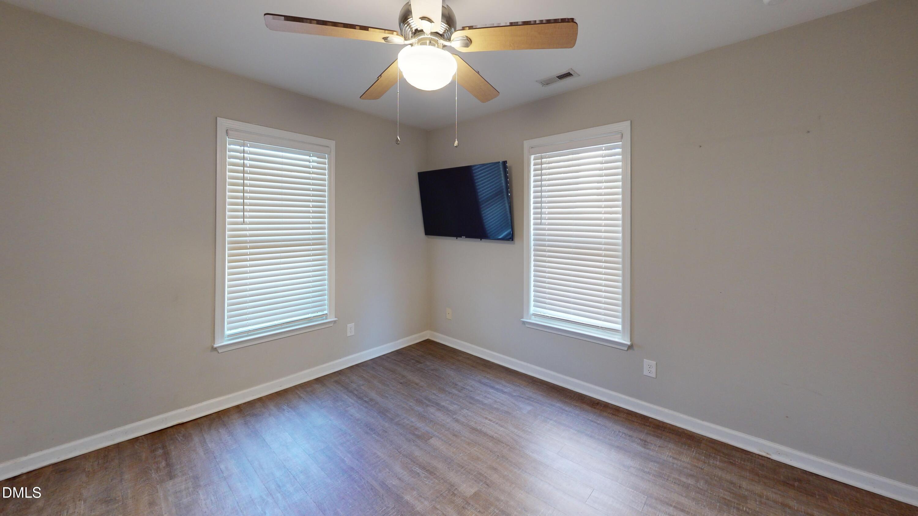 1312 South State Street, Unit A Raleigh, NC 27610 - Photo 6 of 12 an empty room with wooden floor and windows