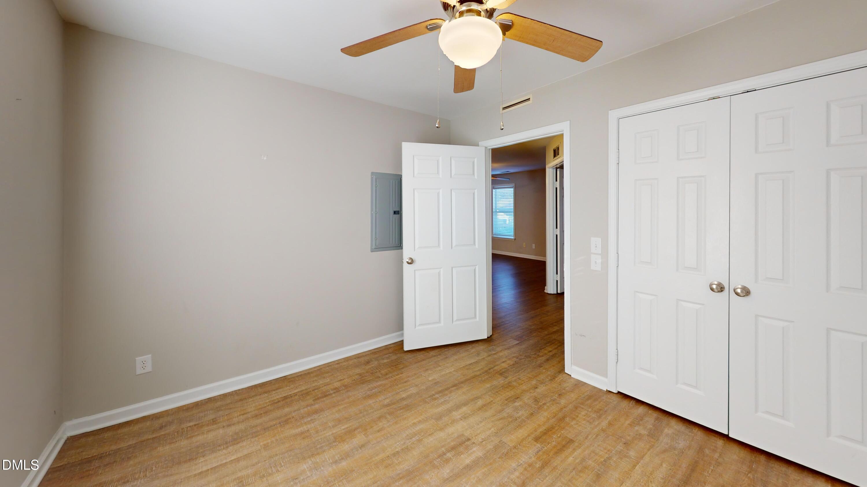 1312 South State Street, Unit A Raleigh, NC 27610 - Photo 7 of 12 an empty room with wooden floor closet and ceiling fan