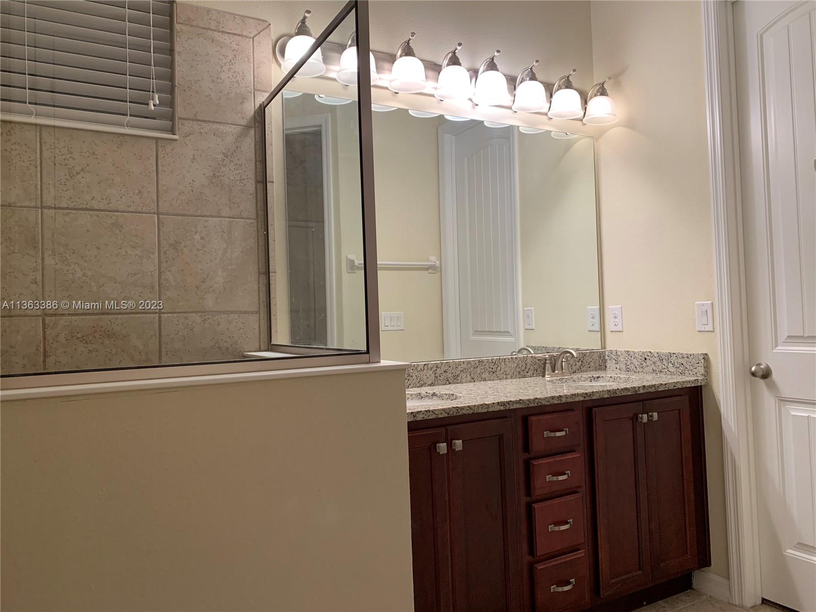 13832 Summerport Trail Loop Windermere, FL 34786 - Photo 12 of 39 a bathroom with a granite countertop sink a large mirror and a shower