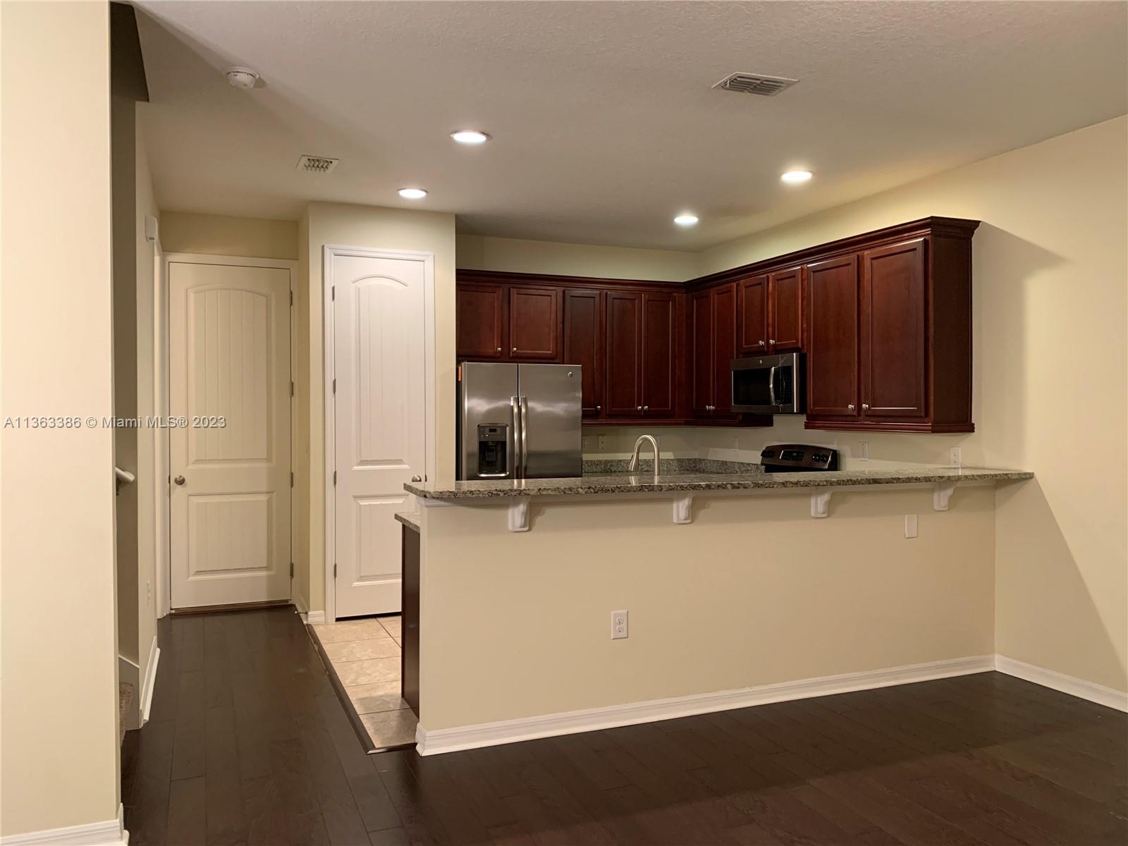 13832 Summerport Trail Loop Windermere, FL 34786 - Photo 4 of 39 a kitchen with kitchen island a sink appliances and cabinets