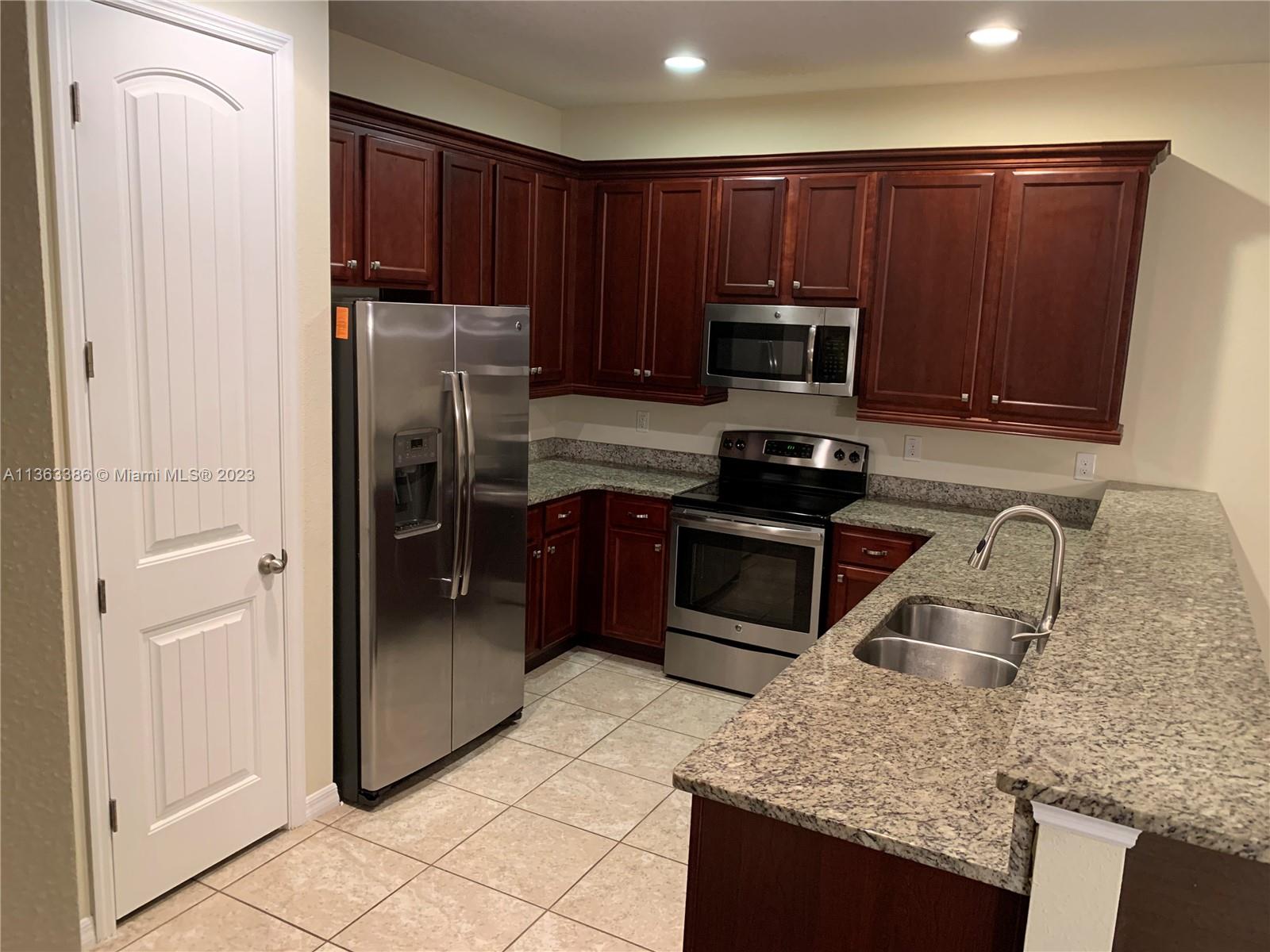 13832 Summerport Trail Loop Windermere, FL 34786 - Photo 8 of 39 a kitchen with granite countertop wooden cabinets and stainless steel appliances