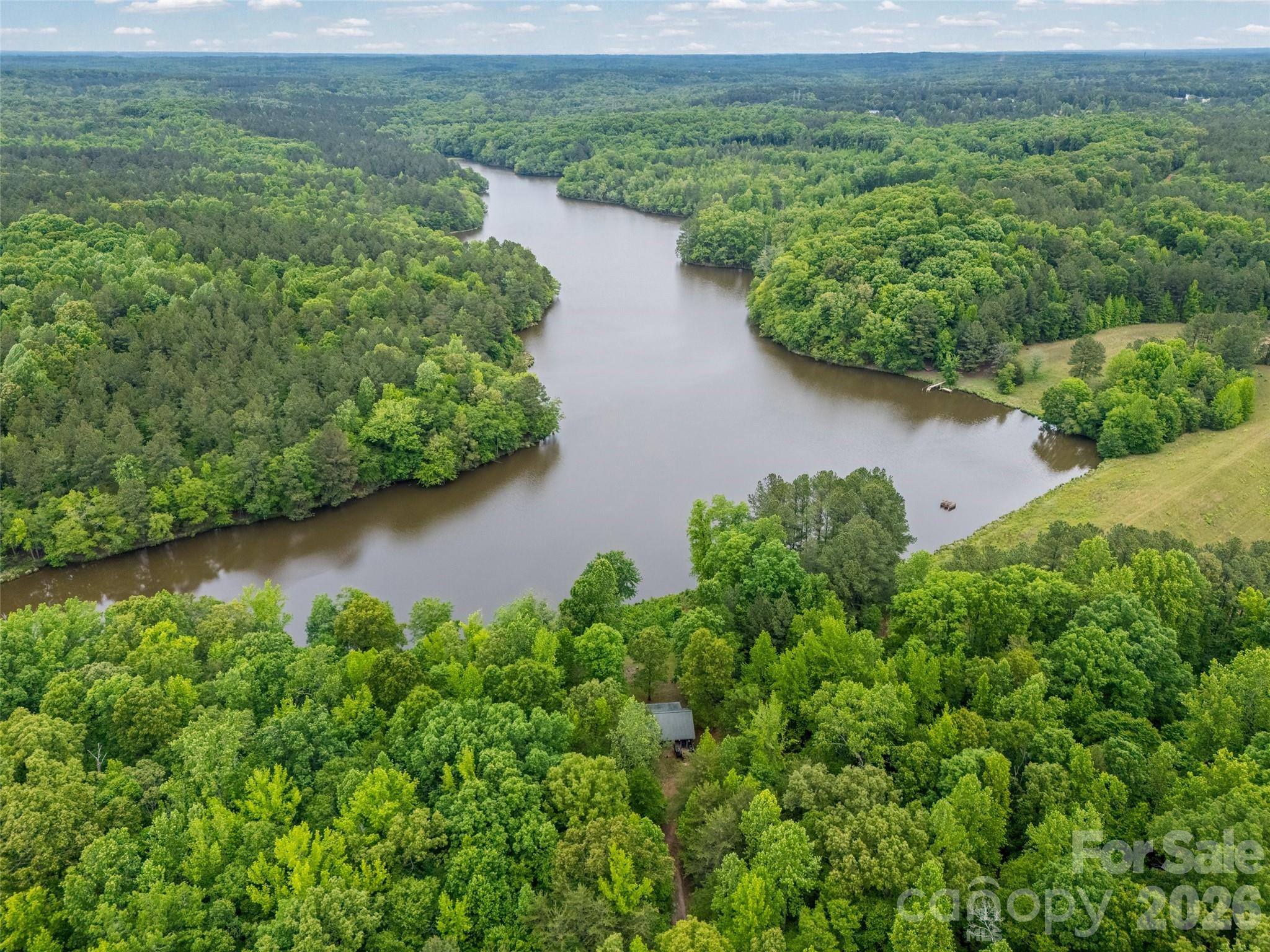 an aerial view of a house with a yard and lake view