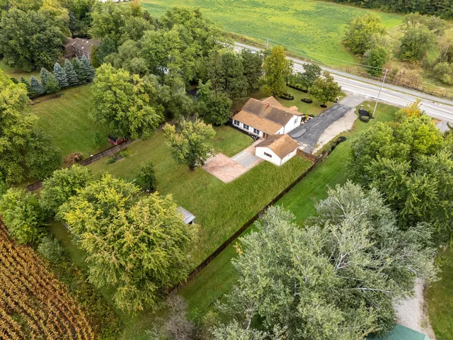 an aerial view of residential houses with outdoor space and trees