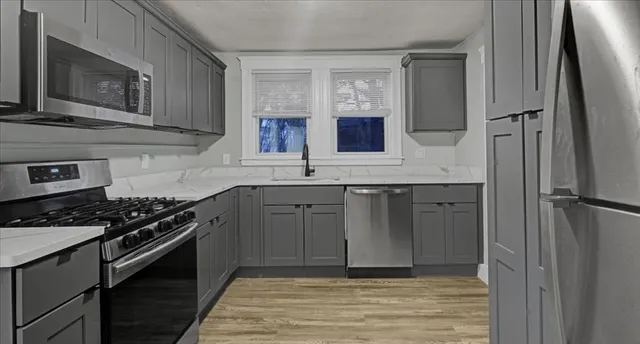 a kitchen with stainless steel appliances granite countertop a stove a sink and a refrigerator