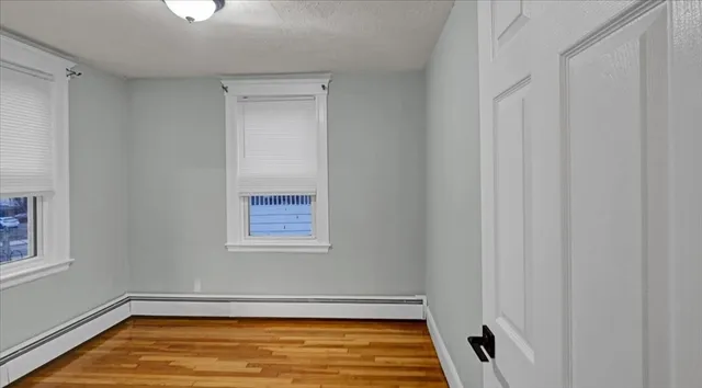 a view of a big room with wooden floor and windows
