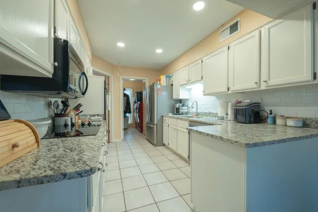 a kitchen with stainless steel appliances granite countertop a sink stove and cabinets