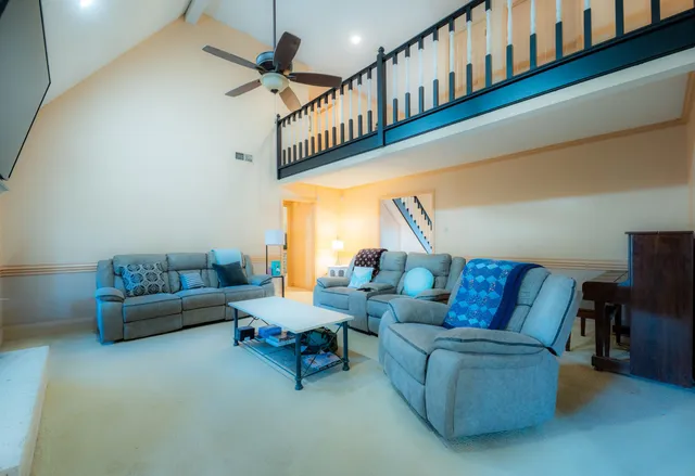 a living room with furniture and a ceiling fan