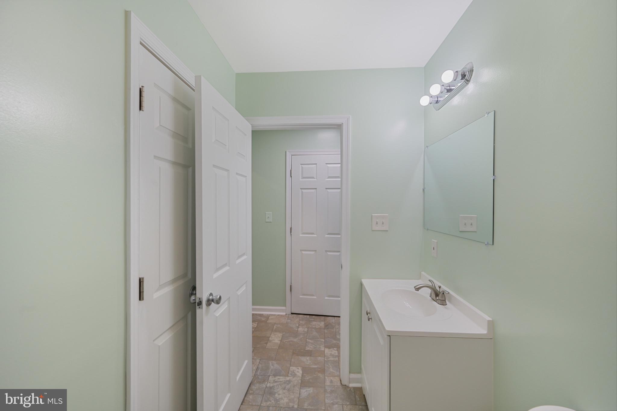 323 Wye Road Essex, MD 21221 - Photo 15 of 35 a bathroom with a sink a mirror and a shower