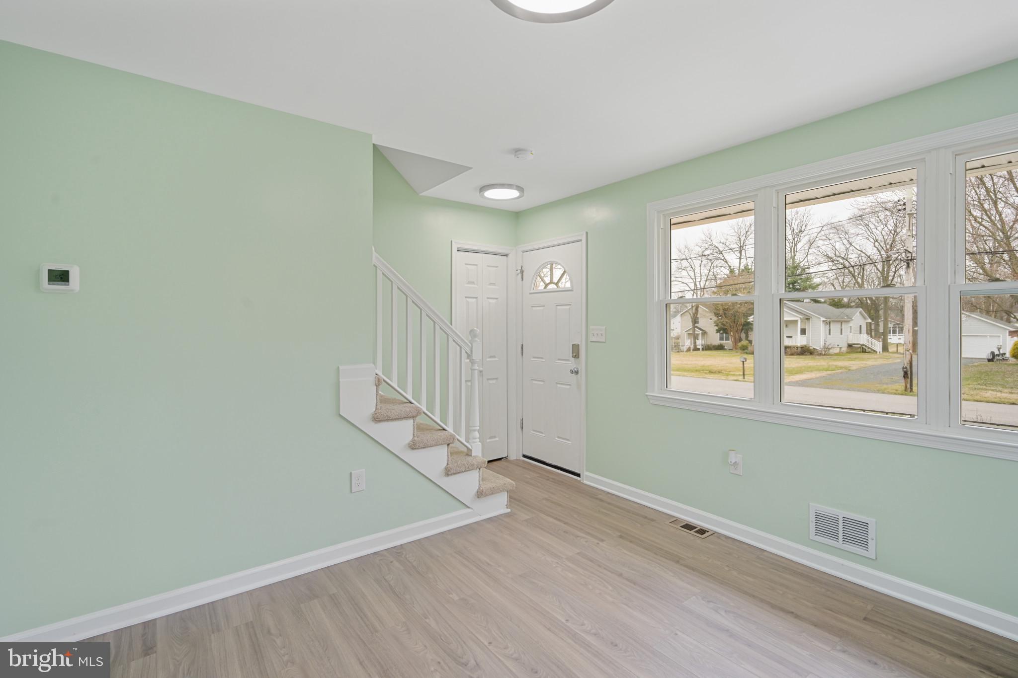 323 Wye Road Essex, MD 21221 - Photo 7 of 35 an empty room with wooden floor and windows