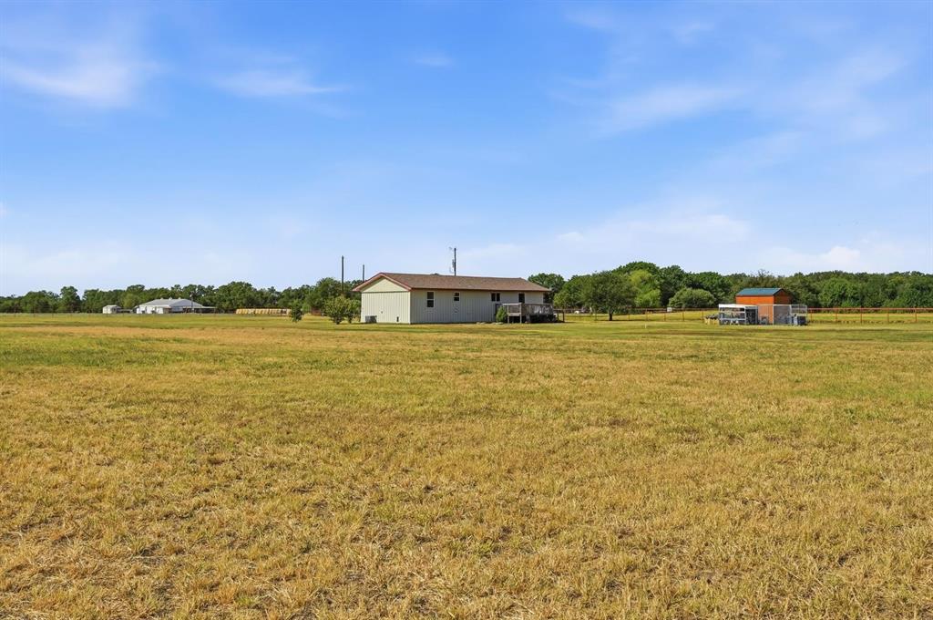 1802 Batey Road Collinsville, TX 76233 - Photo 27 of 33 Expansive grounds featuring a detached structure and a residence with an exterior deck