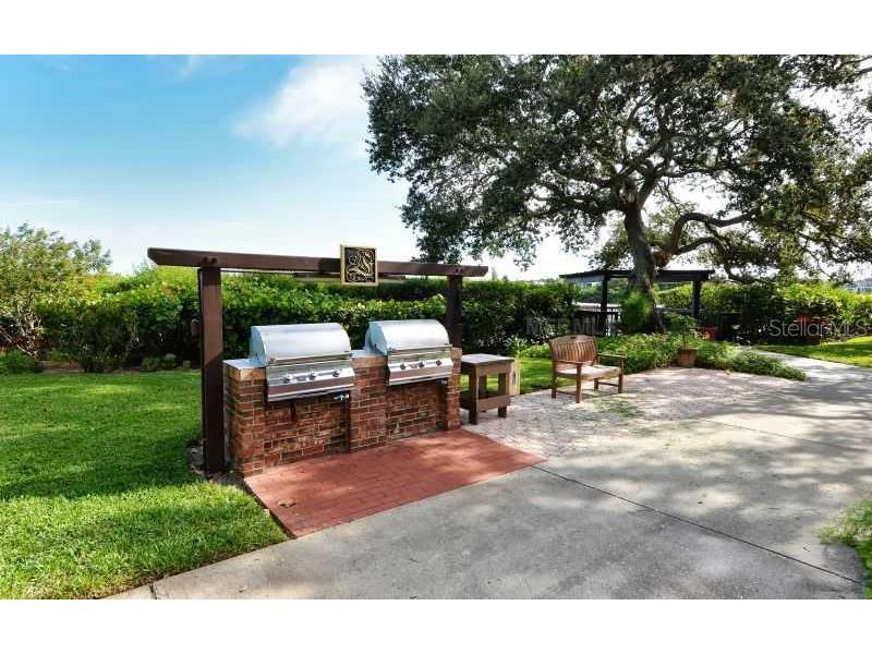6285 Midnight Pass Road, Unit 403 Sarasota, FL 34242 - Photo 33 of 51 a view of a patio with table and chairs under an umbrella