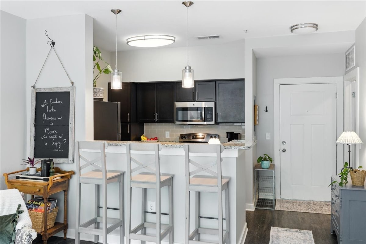 414 Rosedale Avenue, Unit 211 Nashville, TN 37211 - Photo 3 of 23 a kitchen with stainless steel appliances kitchen island granite countertop a refrigerator a stove a sink dishwasher and white cabinets with wooden floor