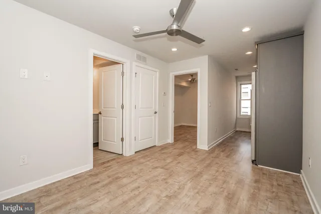 an empty room with fan and entrance