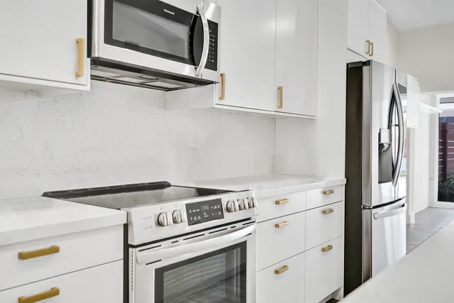 a large kitchen with kitchen island a sink a stove and a refrigerator