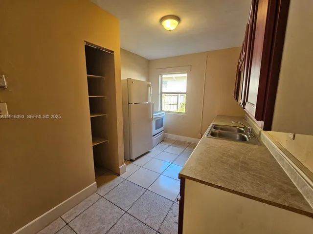 a room with a bed and a refrigerator